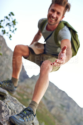Buy stock photo Shot of a handsome young man offering you a hand up the mountain