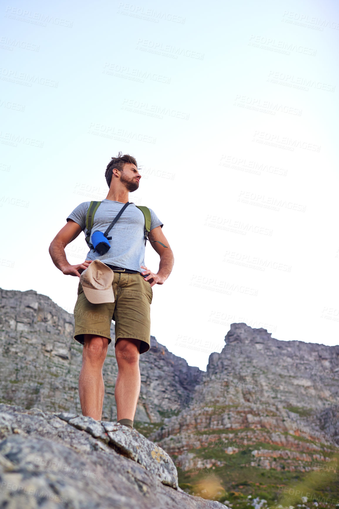 Buy stock photo Shot of a handsome young man enjoying the view while hiking