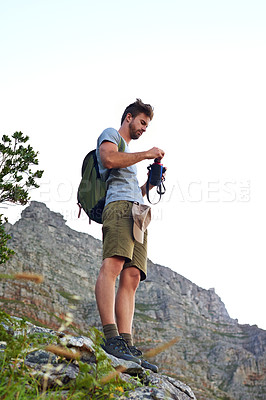 Buy stock photo Shot of a handsome young man opening a bottle of water while hiking
