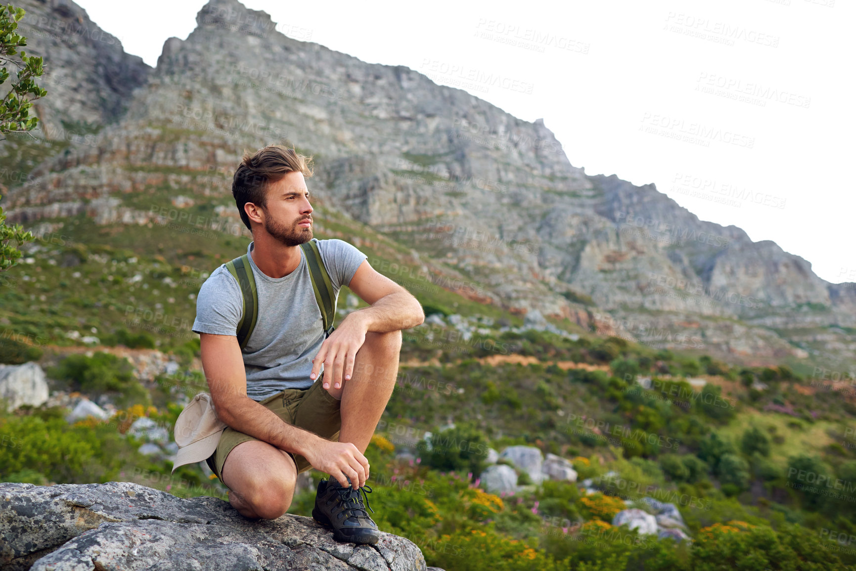 Buy stock photo Shot of a handsome young man enjoying the view while hiking