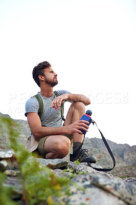 Buy stock photo Shot of a handsome young man enjoying the view while hiking