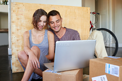 Buy stock photo Shot of an affectionate young couple using a laptop on the floor at home