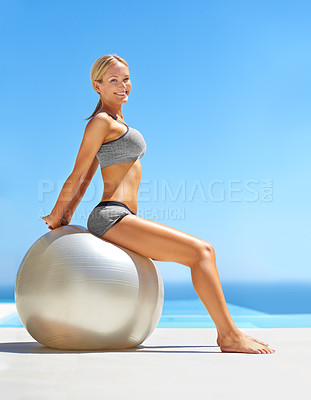 Buy stock photo Portrait of an attractive young woman working out with an exercise ball by a swimming pool