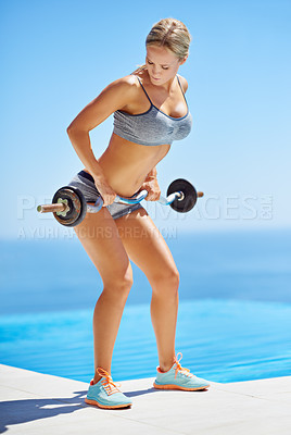 Buy stock photo Full length shot of an attractive young woman exercising with weights outside