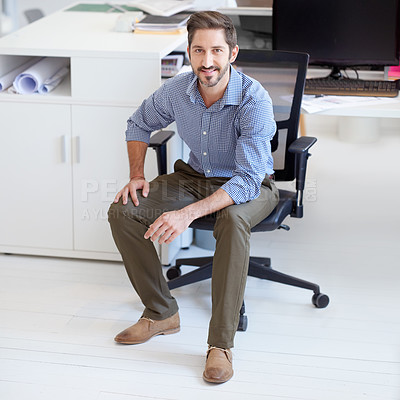 Buy stock photo Portrait of a young designer sitting at his workstation in an office