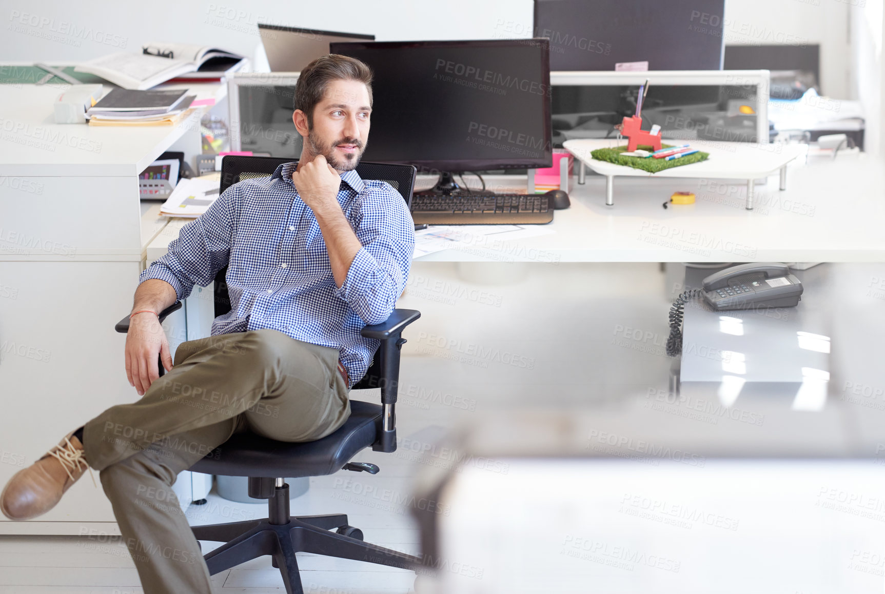 Buy stock photo Shot of a young designer sitting at his workstation in an office