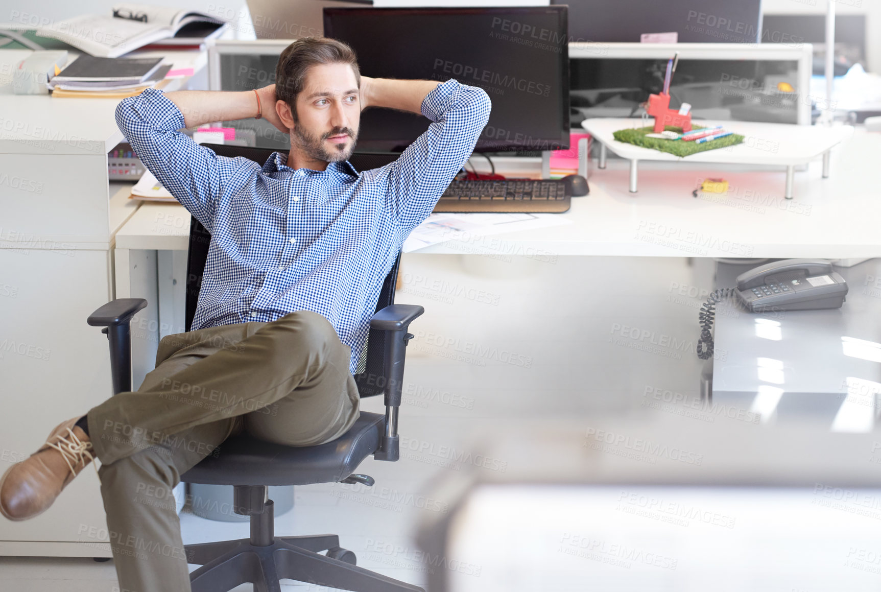 Buy stock photo Shot of a young designer sitting at his workstation in an office