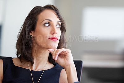 Buy stock photo Shot of an attractive businesswoman sitting in a chair in an office
