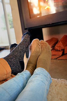 Buy stock photo Cropped shot of a couple sitting by the fireplace