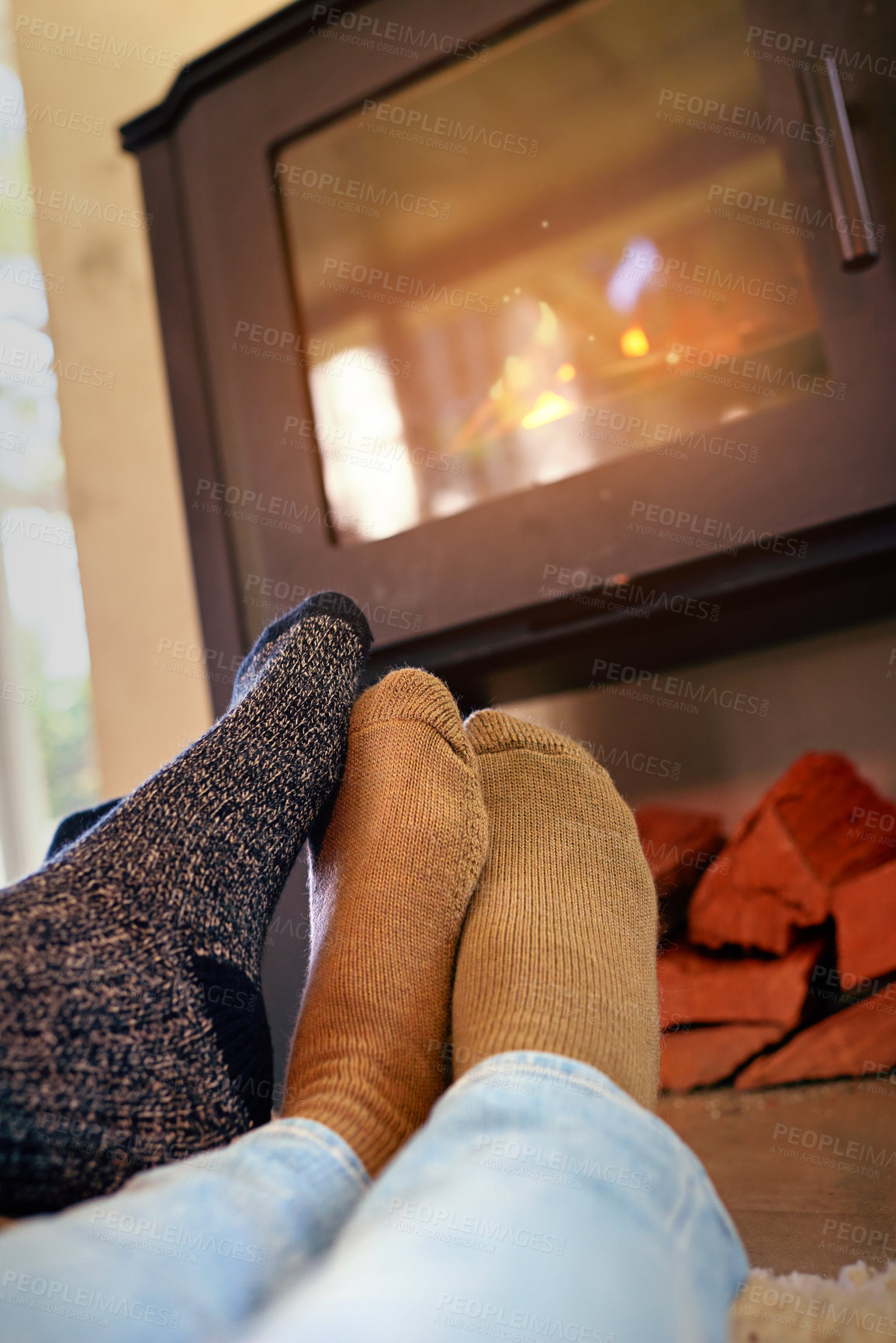Buy stock photo Cropped shot of a couple sitting by the fireplace
