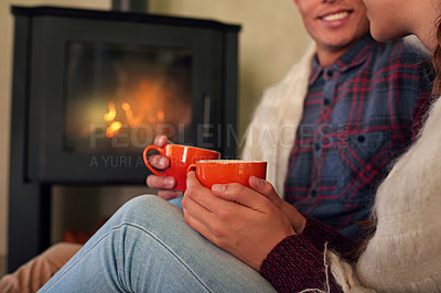 Buy stock photo Cropped shot of a young couple drinking hot chocolate by the fireplace