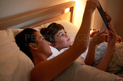 Buy stock photo Mother, boy and tablet in bedroom at night for care, bonding or to watch movies together in family house. Mom, child and home on digital touchscreen for cartoon. film or streaming subscription in bed