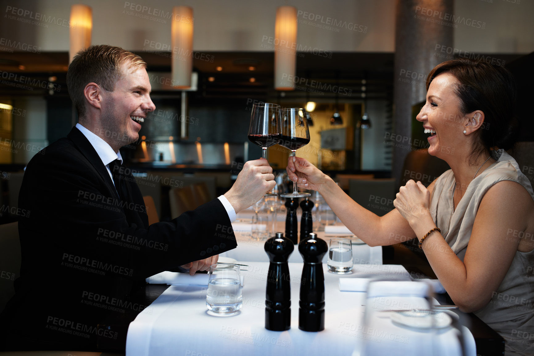 Buy stock photo Couple, dinner and wine glass for cheers at table, celebration and anniversary in restaurant. Happy, alcohol and smile for toast with man and wife, marriage and romantic for luxury date at night