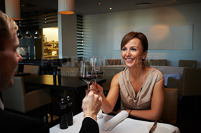 Buy stock photo Shot of a mature couple enjoying a glass of wine at a fine restaurant