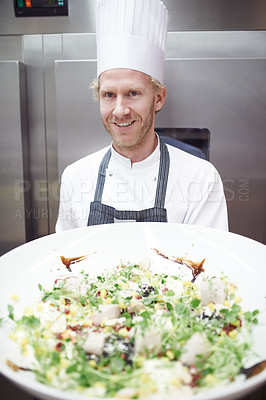 Buy stock photo Portrait of a chef holding a large bowl of salad in a professional kitchen