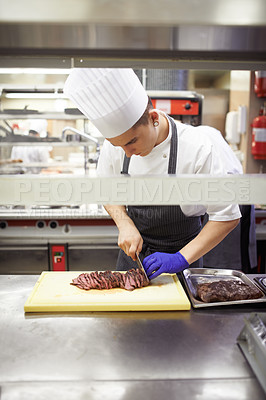 Buy stock photo Professional, chef and man cutting meat, restaurant and cook staff and gourmet meal prep. Serious, catering and culinary skills for fine dining, nutrition and hospitality industry with busy employee