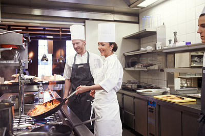 Buy stock photo Shot of chefs flambeing in a restaurant kitchen