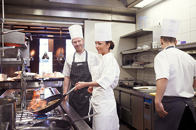 Buy stock photo Shot of chefs flambeing in a restaurant kitchen