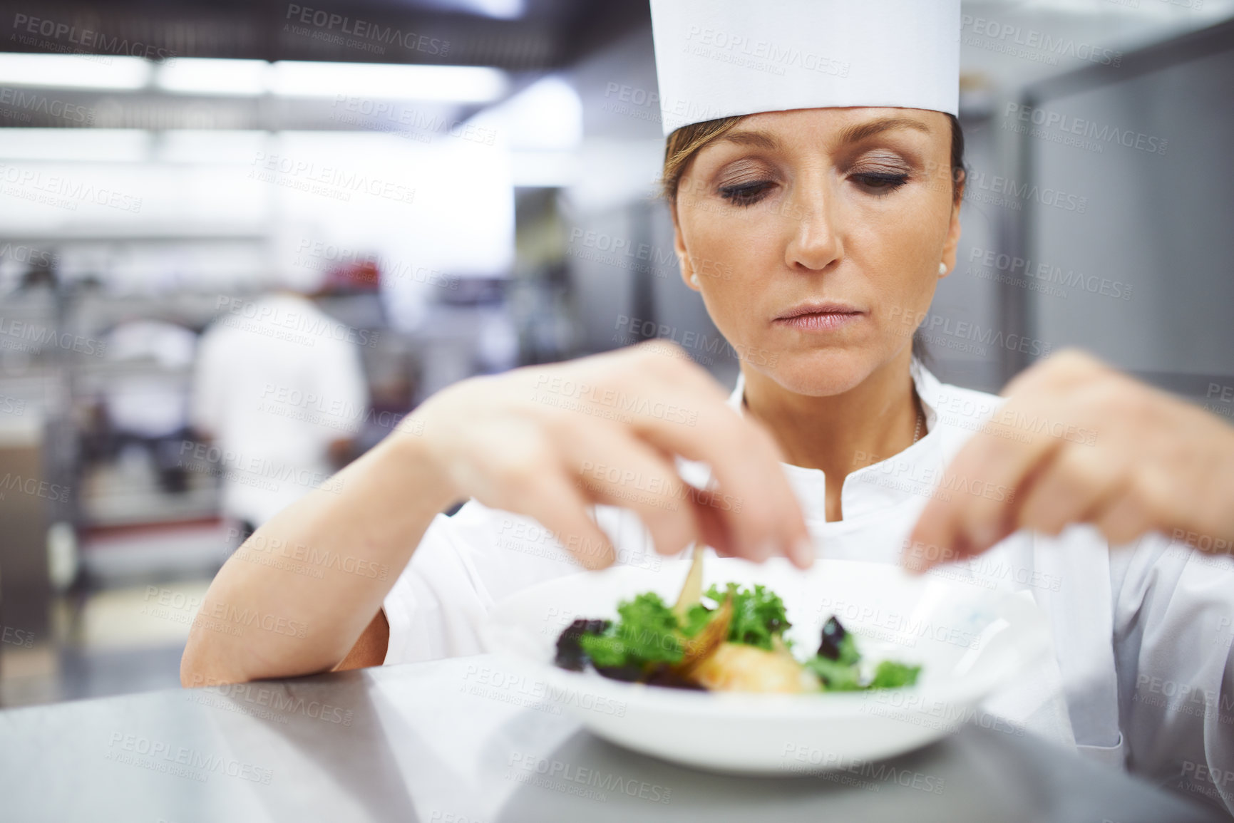 Buy stock photo Cooking, chef and woman in restaurant serving dish for gourmet lunch, fine dining and dinner. Kitchen, catering and person with seasoning, flavor and ingredients for culinary cuisine, salad or food