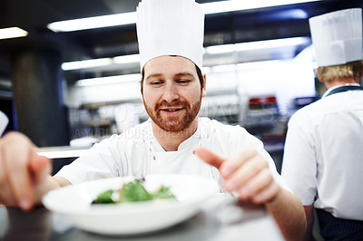 Buy stock photo Cooking, chef and man in restaurant kitchen to decorate food plate, fine dining and hospitality service. Garnishing, culinary professional and preparing meal, lunch and dinner for hotel catering