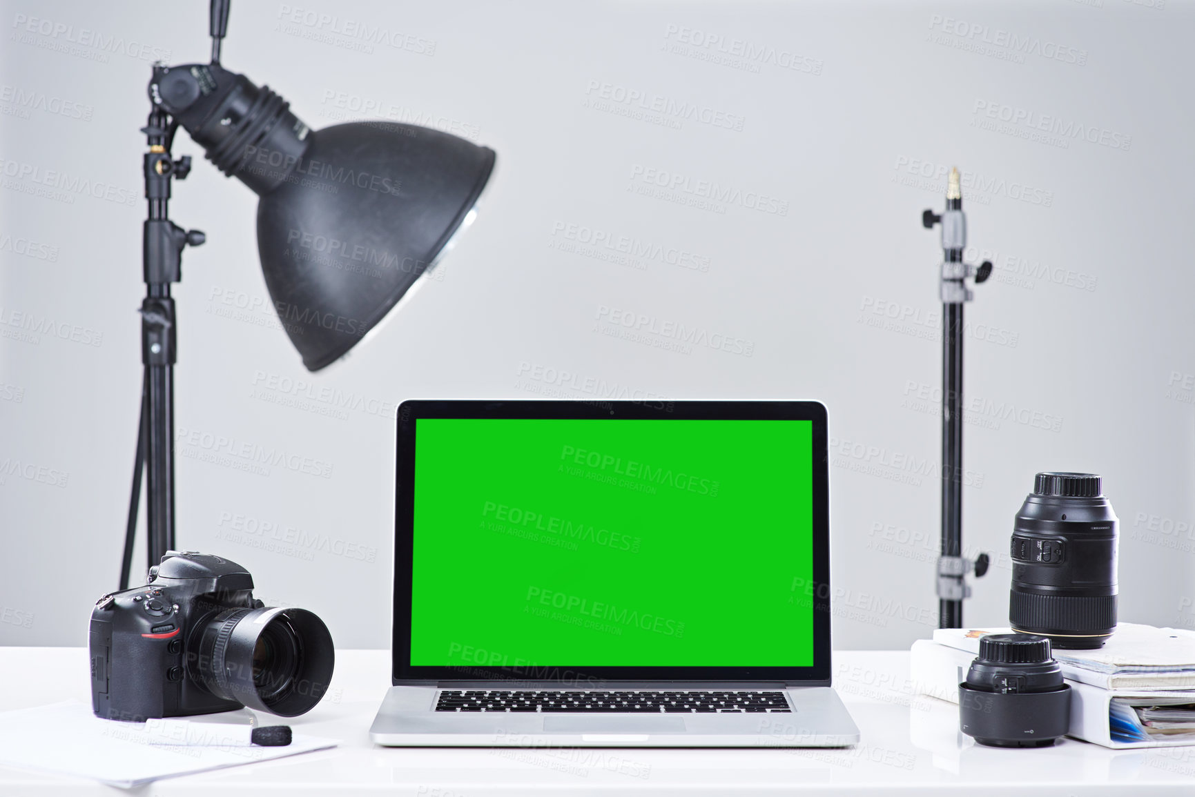 Buy stock photo Shot of a laptop with a green screen surrounded by photography equipment