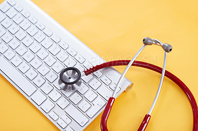 Buy stock photo Concept shot of a keyboard and stethoscope on a yellow background
