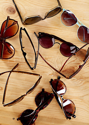 Buy stock photo Shot of a collection of sunglasses on a table top