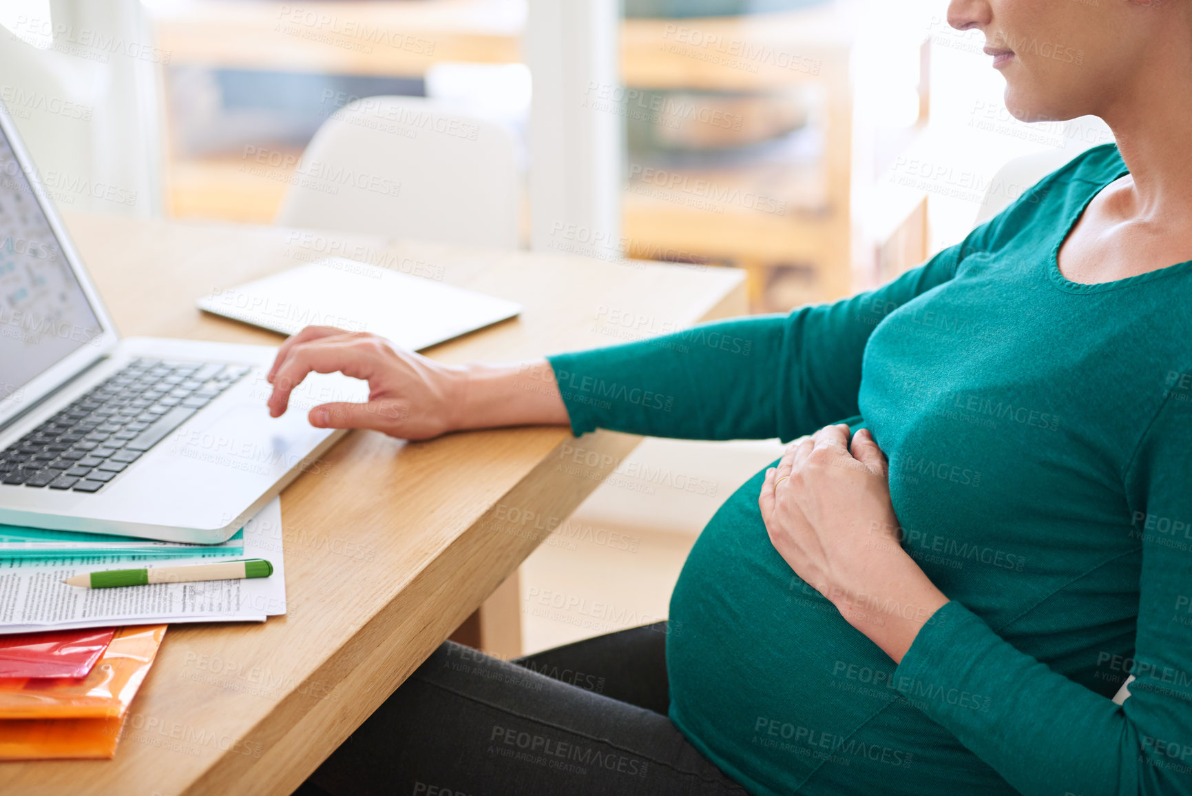 Buy stock photo Cropped shot of a pregnant woman using her laptop at home