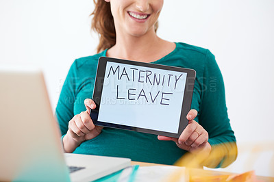 Buy stock photo A pregnant woman holding a tablet with the words 'maternity leave' on the screen