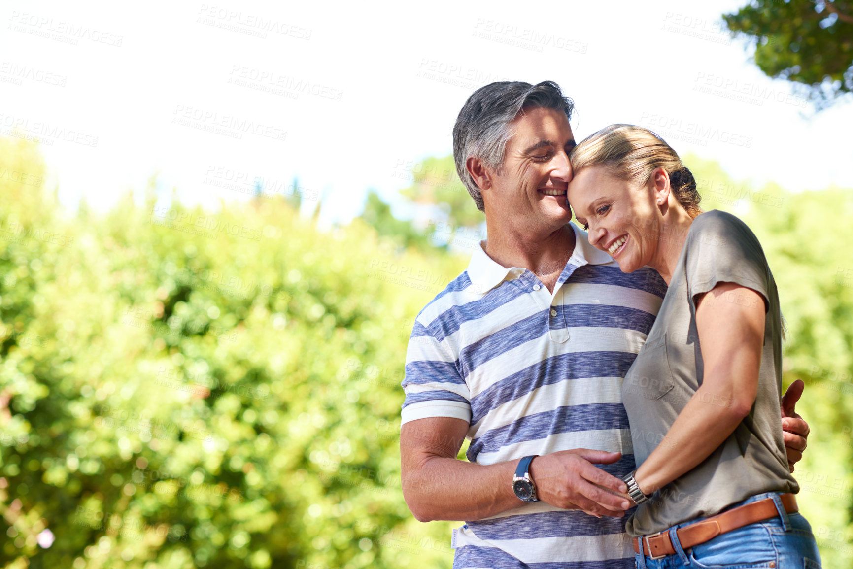 Buy stock photo Cropped shot of an affectionate mature couple enjoying a day in the park