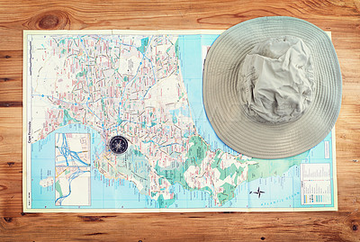 Buy stock photo Hat, map and above with compass on table for itinerary schedule, adventure explore and direction. Vintage, geography and location with holiday flat lay for tourism, navigation and travel discovery