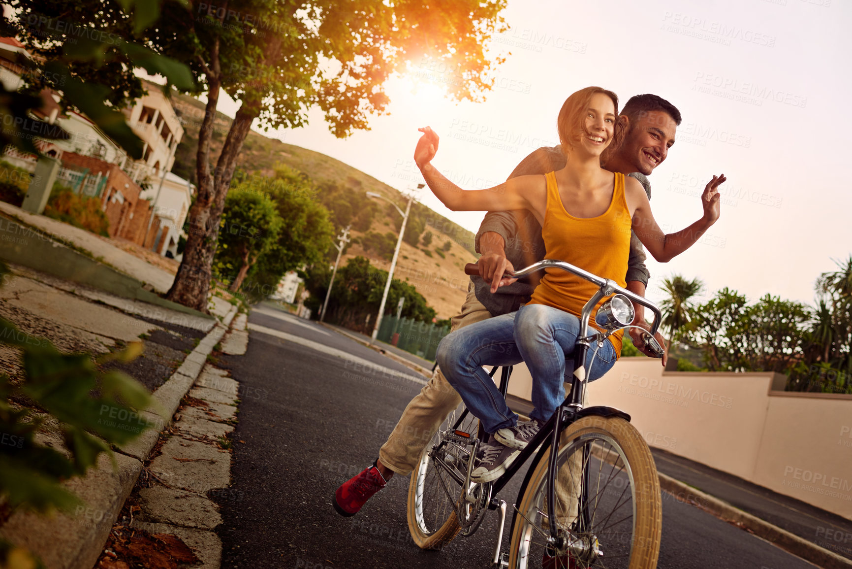 Buy stock photo Shot of a happy young couple enjoying a bicycle ride together