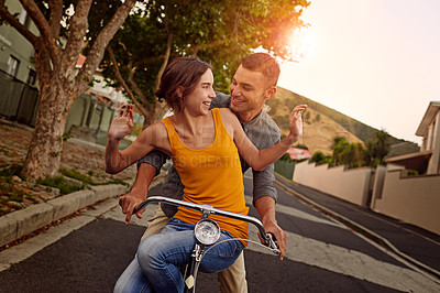 Buy stock photo Shot of a happy young couple enjoying a bicycle ride together