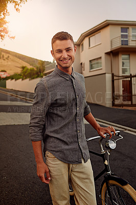 Buy stock photo A young man standing with his bicycle outdoors