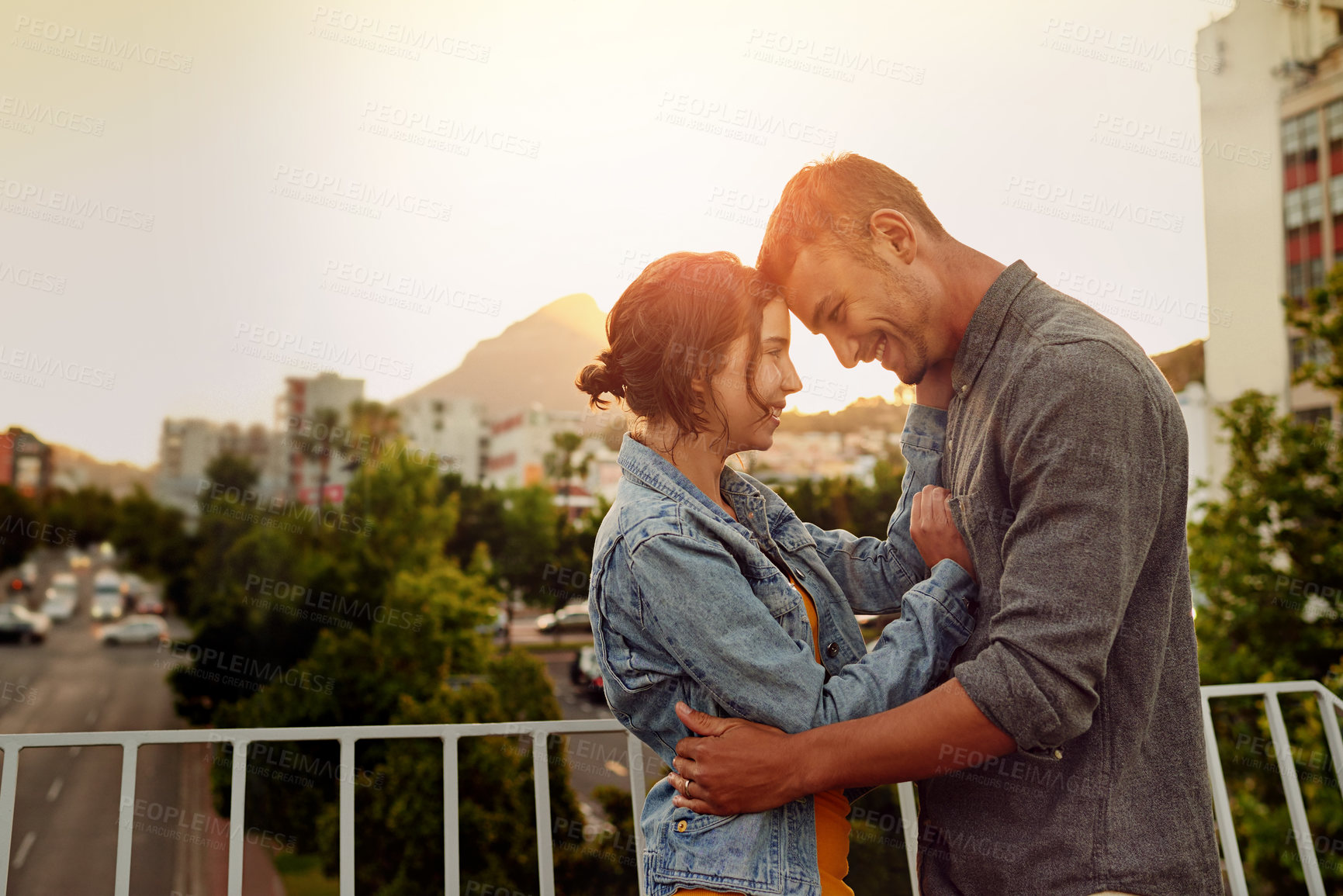 Buy stock photo Shot of a happy young couple enjoying a romantic moment in the city