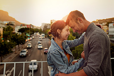 Buy stock photo Shot of a happy young couple enjoying a romantic moment in the city