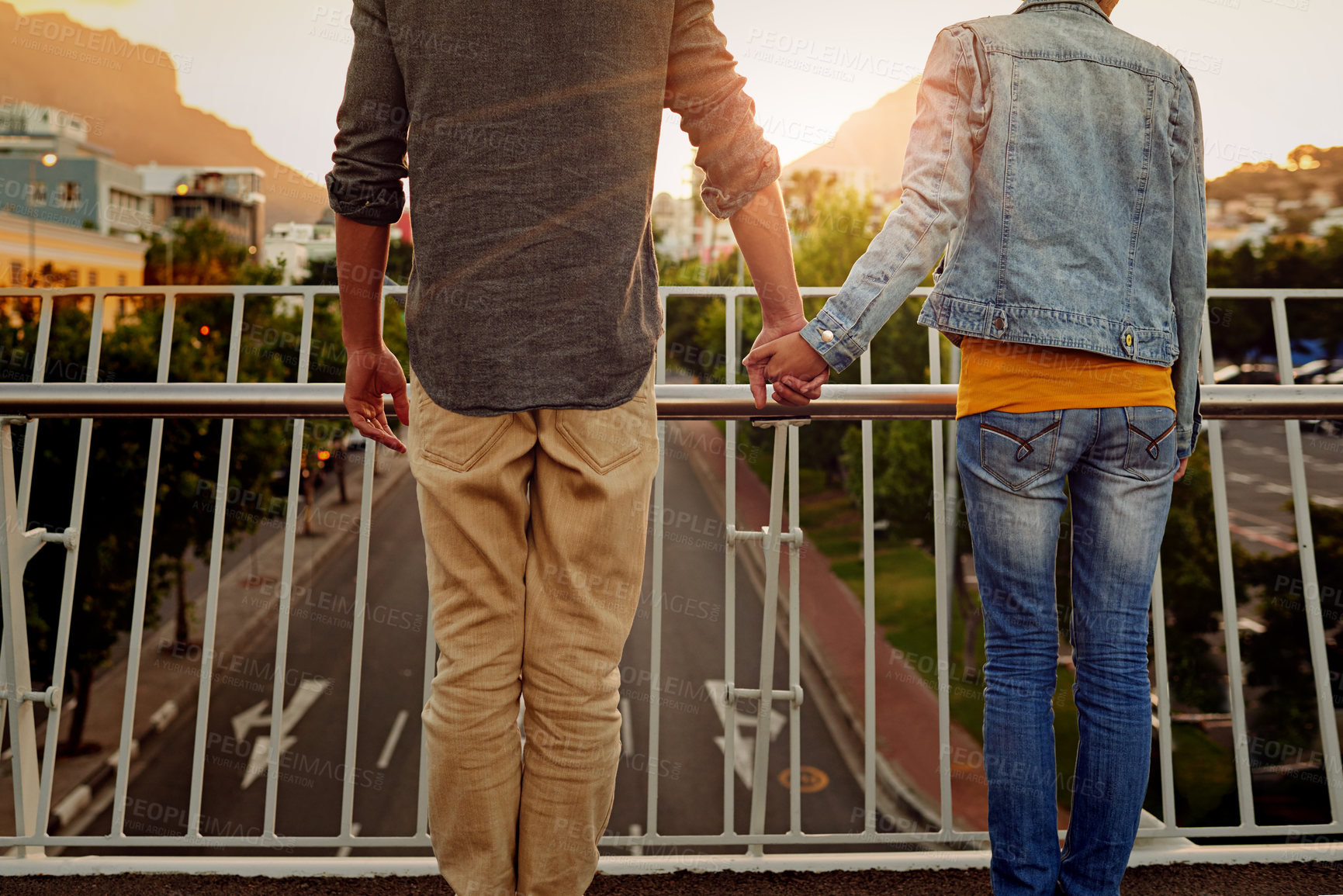 Buy stock photo Rearview shot of a couple standing together on a city bridge and looking at the view