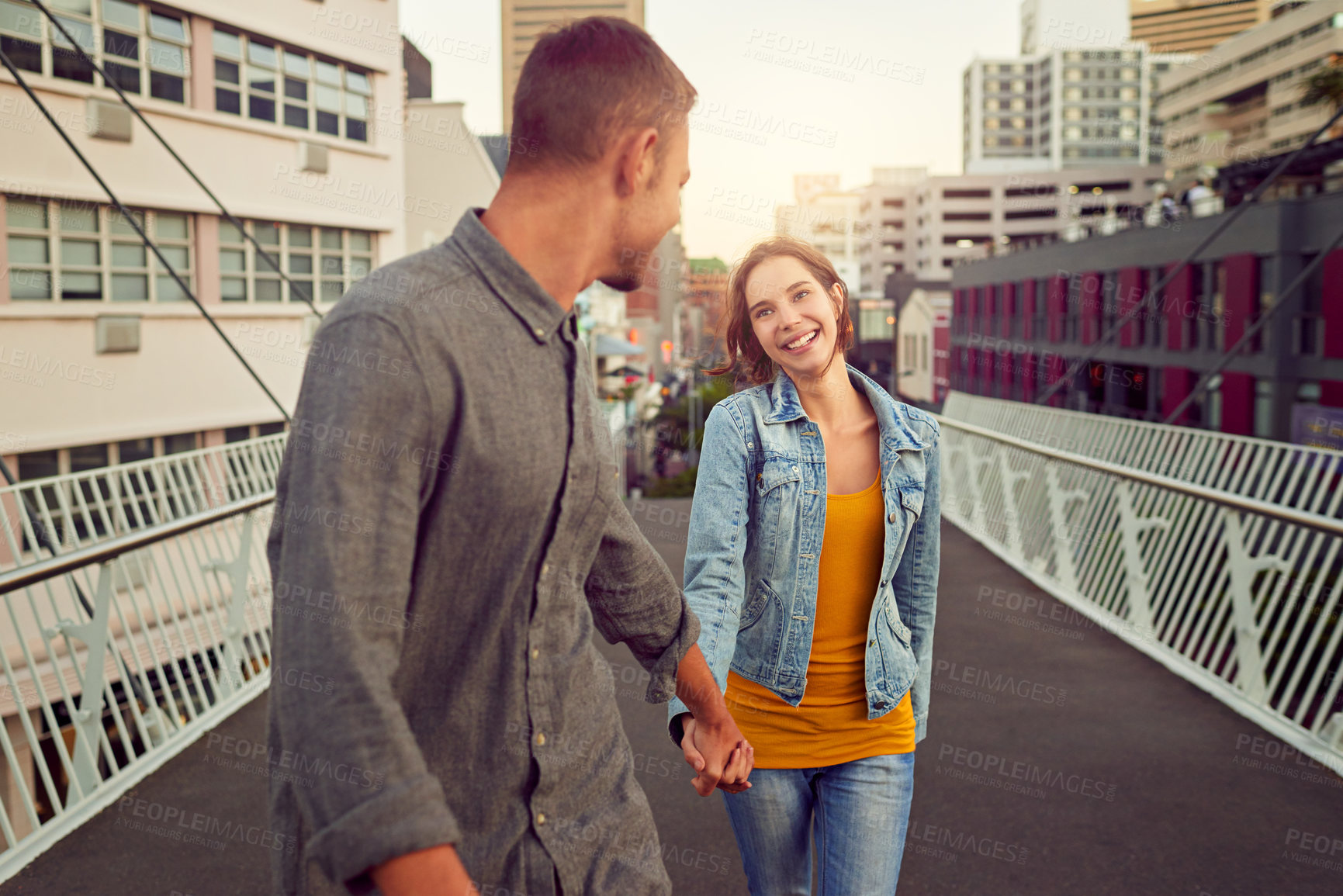 Buy stock photo Shot of a happy young couple enjoying a romantic walk together in the city