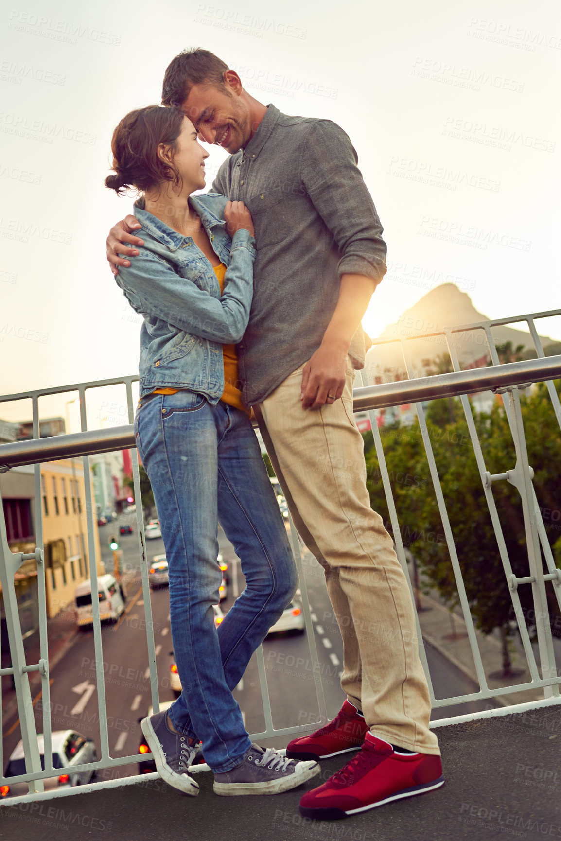 Buy stock photo Shot of a happy young couple enjoying a romantic moment in the city