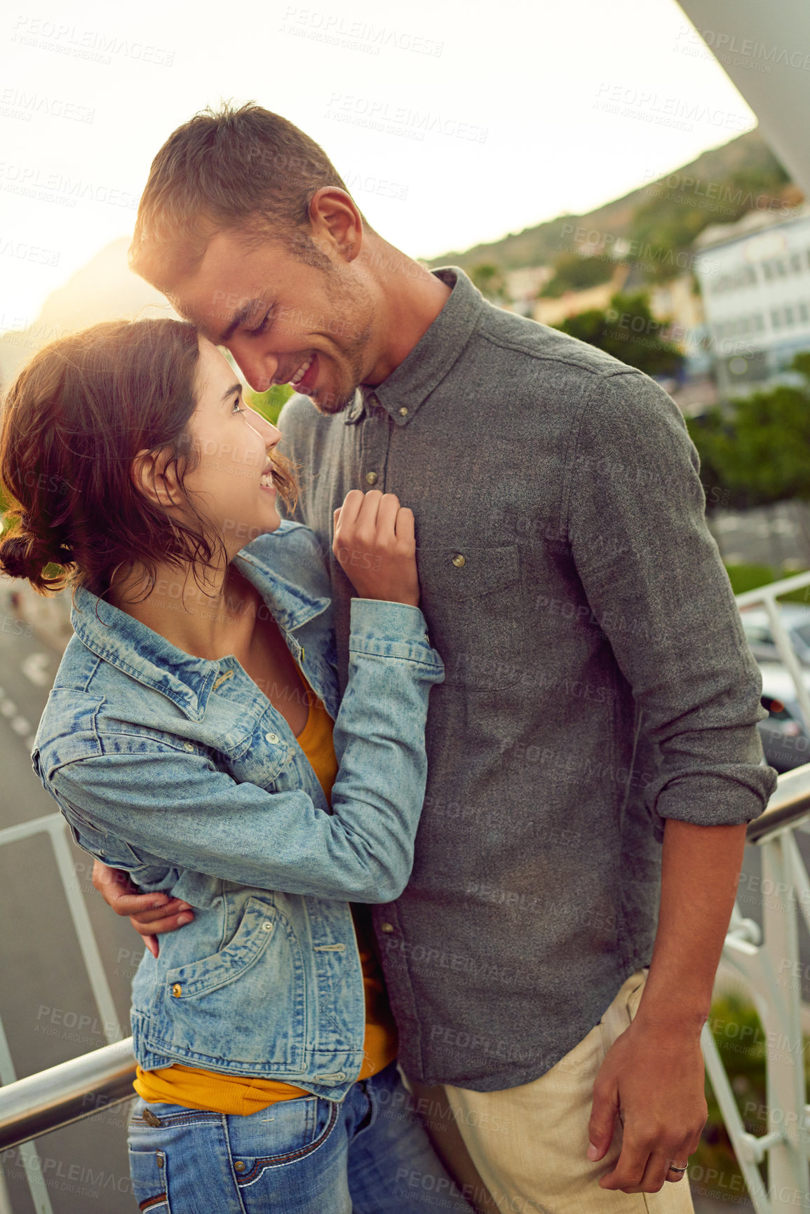 Buy stock photo Shot of a happy young couple enjoying a romantic moment in the city