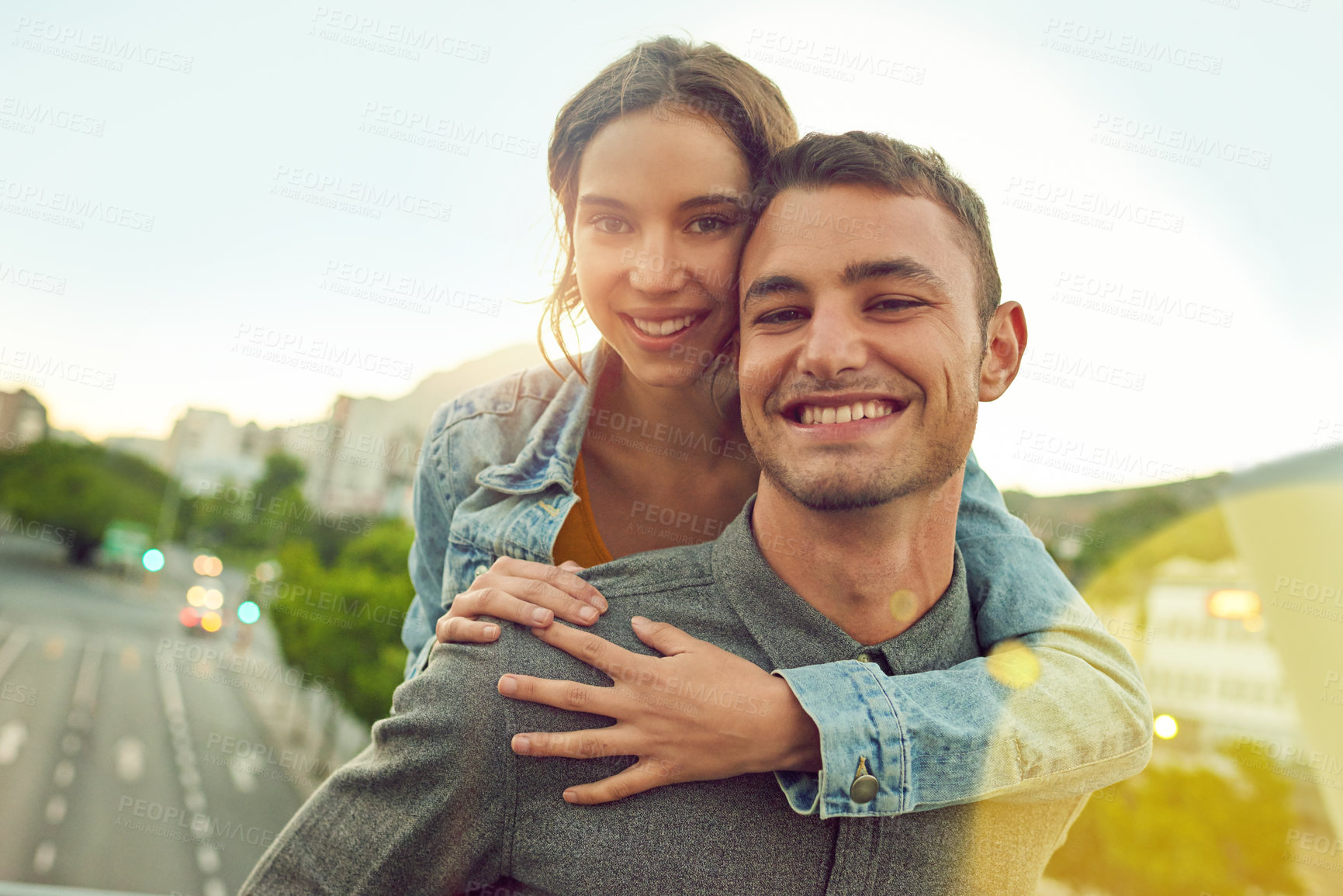 Buy stock photo Portrait, couple and piggyback for love outdoor on vacation, honeymoon and bonding together in city. People, happy and hug with support for urban travel, healthy relationship and romance commitment
