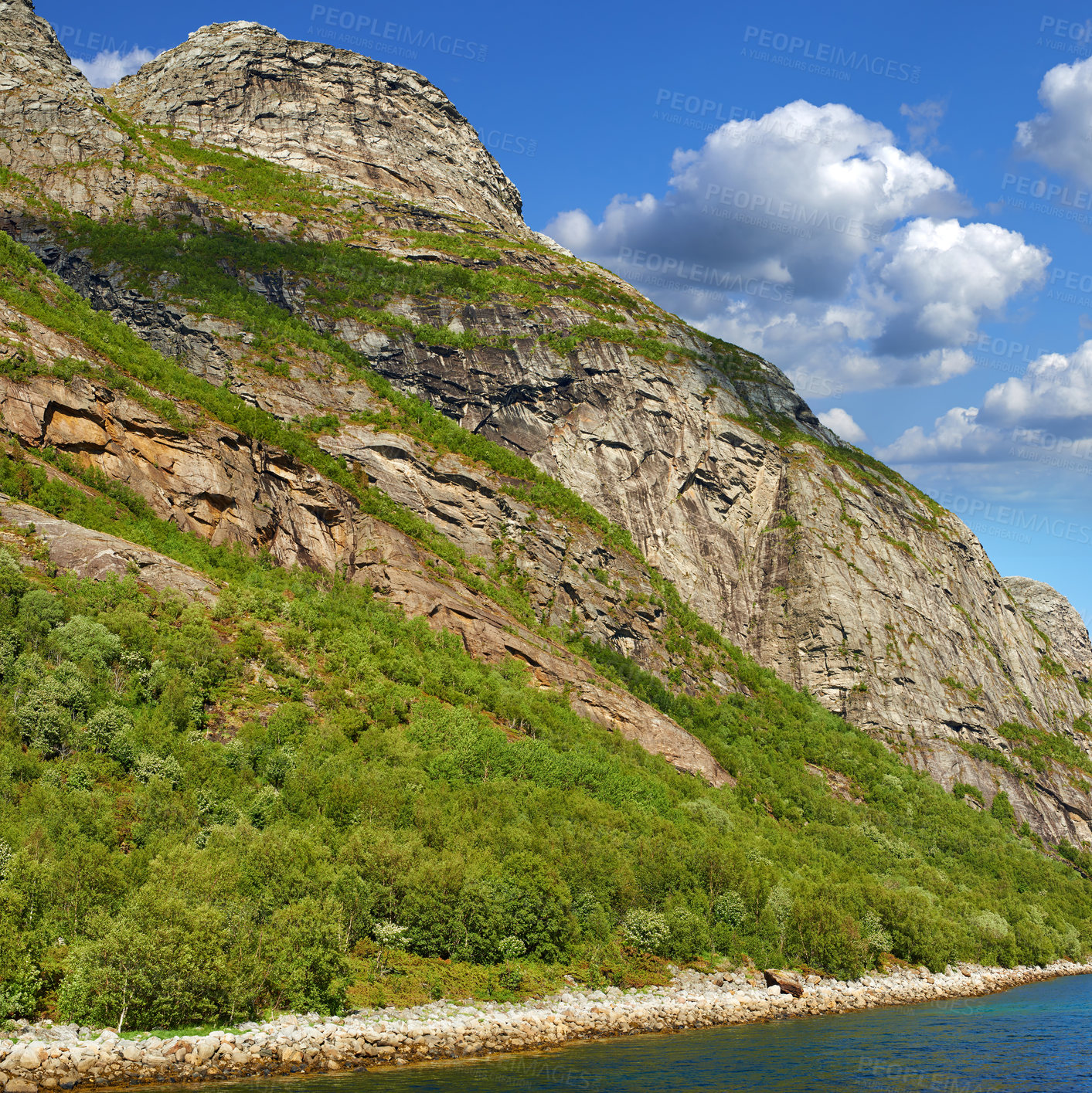 Buy stock photo The picturesque coast of the mountain lake of Norway,
close to the city of Bodo. Hiking trail to the beautiful mountain in Nordland with a cloudy blue sky. Lush hill with pasture near water outdoors