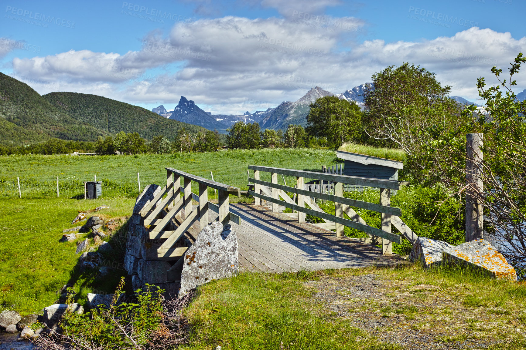 Buy stock photo Landscape of wooden bridge in remote green countryside of Bodo in Nordland, Norway. Infrastructure and built crossing in eco meadow and environment fields. Toursim and exploring nature during the day