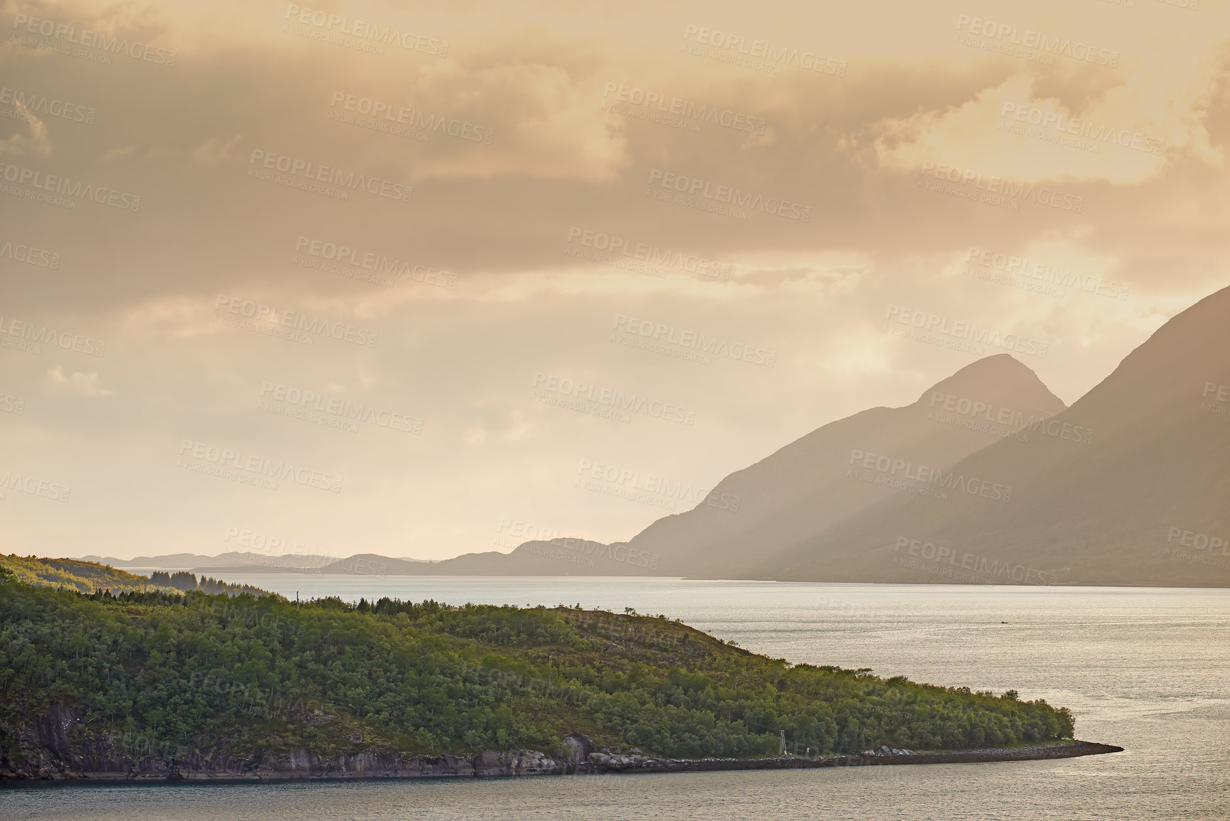 Buy stock photo Landscape, mountains and fjord with ocean, clouds and sky with sunset, ecosystem and mock up space by woods. Outdoor, sea and hill with forest, growth and coastal environment in summer in Norway