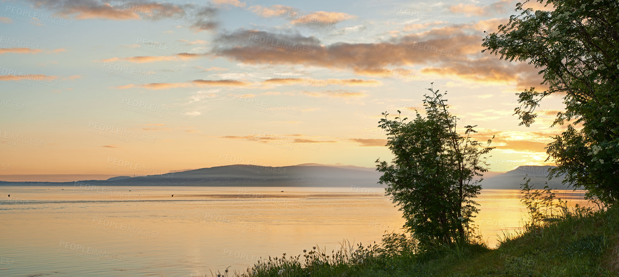 Buy stock photo Copyspace and scenic landscape of  a lake or river and mountains north of polar and arctic circle in Norway during sunset. Trees and calm sea in remote area with clouds. Travel to nature for holiday