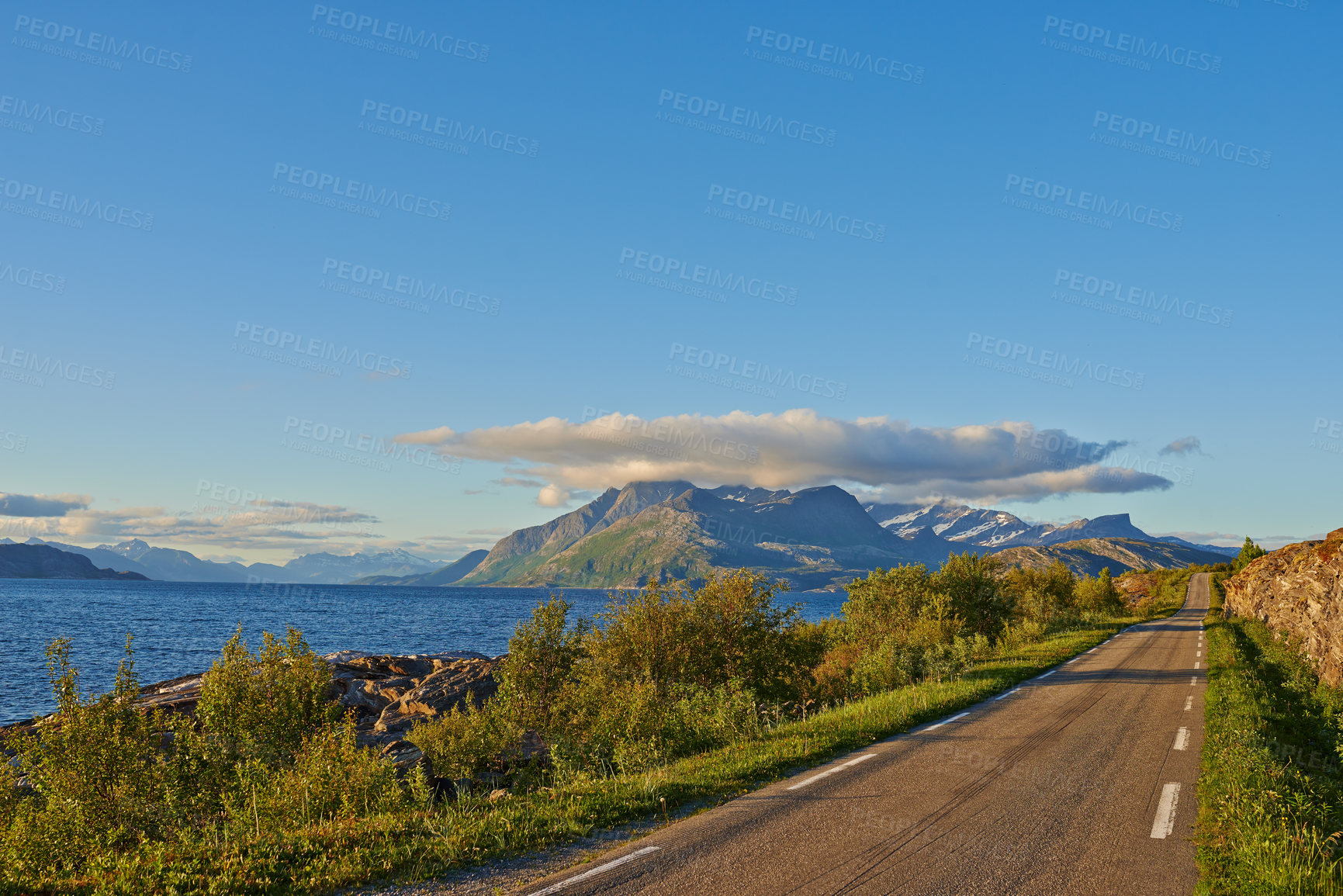 Buy stock photo Fjord, road and sky with clouds by mountains, nature and trees for transport system in summer. Landscape, mockup and space with highway, infrastructure and travel in environment by street in Norway