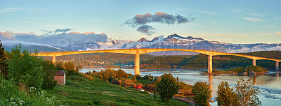 Buy stock photo Landscape view of Saltstraumen in Nordland, Norway in winter. Scenery of infrastructure and bridge over a river and stream with snow capped mountains in the background. Traveling abroad and overseas