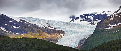 Buy stock photo Glacier, countryside and mountain ice with forest in winter for travel, climbing and hiking. Landscape, nature and view of green environment, clouds and Norway woods for calm adventure on rocks