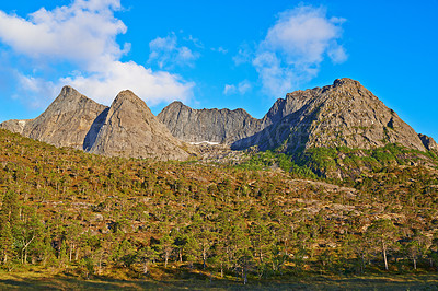 Buy stock photo Mountain, greenery and clouds in blue sky in nature by journey for travel destination in Norway. Environment, landscape and peak for vacation, holiday or trip to landmark in countryside scenery.