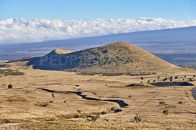 Buy stock photo The world's largest active volcano Mauna Loa in Hawaii, Big Island, Hawaii with blue skies and clouds in the background of the majestic hills. Dry, rocky, and rough terrain on a vast rural landscape